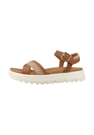 Brown sandal with two straps, one textured, ankle buckle, cushioned footbed, and thick white sole with deep treads.
