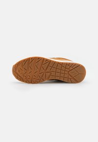 Rubber sneaker sole with a textured, zigzag pattern in tan. Features a smooth border and a reinforced heel for enhanced durability.