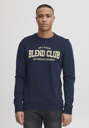 Marineblauwe sweatshirt met lange mouwen, geribde manchetten en zoom. Voorzijde tekst in crèmekleur: "BLEND CLUB LOS ANGELES ORIGINAL." Klassieke pasvorm.