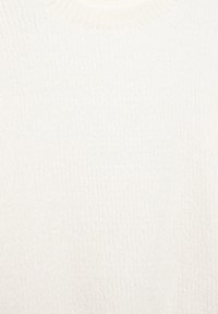 Fehér kötött pulóver, textúrált bordázott mintával és kerek nyakkivágással. Az anyag lágy és enyhén bolyhos hatású.