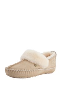 Beige suede pantoffel met een fluffy witte schapenvacht manchet, gestikte details langs de randen en een gestructureerde rubberen zool voor grip.