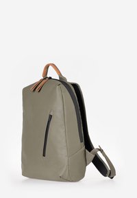 Zaino in pelle verde con un design minimalista, manico superiore, tasca anteriore con zip e spallacci in tessuto regolabili.