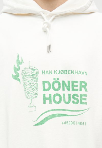 Λευκό φούτερ με κουκούλα με πράσινο γραφικό που απεικονίζει σούβλα ντονέρ κεμπάπ, φλόγες, το κείμενο "HAN KJØBENHAVN DÖNER HOUSE" και κάτω έναν αριθμό τηλεφώνου.