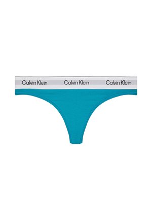 String turquoise avec une ceinture élastique blanche comportant des logos "Calvin Klein" noirs répétés.