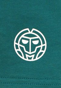 Tela azul verdoso con una textura suave que presenta un logo circular blanco que asemeja un rostro estilizado, delineado con patrones geométricos.