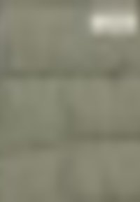 Texturerad ljusgrå yta med rektangulära plattor arrangerade i ett förskjutet mönster; subtila nyansskillnader syns över ytan.