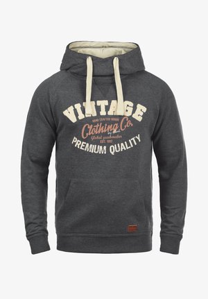 Sudadera gris con capucha y bolsillo frontal, cordones de color crema y gran texto en blanco y naranja que dice "Vintage Clothing Co. Calidad Premium."