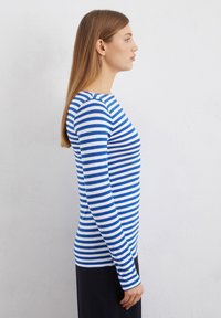 Blue and white striped long-sleeve shirt with a round neckline, fitted design, and soft cotton material. Smooth texture and even pattern.