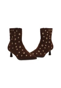 Botines de ante marrón con ojales dorados, punteras afiladas y tacones de 5 cm. Presenta un diseño elegante y una superficie texturizada.