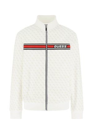 Weiße Jacke mit Reißverschluss und hohem Kragen, dezentem durchgehendem Muster und einem rot-schwarzen horizontalen Streifen über der Brust mit dem Schriftzug "GUESS".