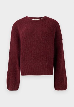Burgundivärinen neulepaita, jossa on pitkät, hieman puffamaiset hihat, ribattu helma ja pörröinen tekstuuri. Yksinkertainen pyöreä pääntie ilman näkyviä kuvioita tai varusteita.