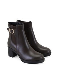 Bottines en cuir marron avec une finition lisse, présentant un talon bloc, des panneaux élastiques latéraux et un accent de boucle à la cheville.