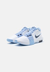 Weiße und hellblaue Sportschuhe mit einem strukturierten Design, abgerundetem Zehenbereich, Schnürsenkeln und einer sichtbaren Luftpolsterung in der Sohle.