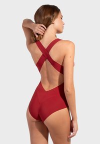 Bañador rojo con un diseño de espalda entrecruzada, que cuenta con una tela suave y elástica y un fondo de cintura alta con un corte en forma de V.