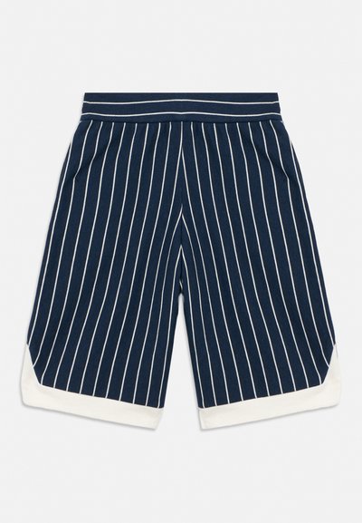 Pantalones cortos azul marino con finas rayas blancas verticales y dobladillos blancos enrollados, con bolsillos y cintura ajustada.