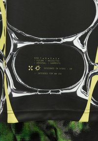 Ένδυμα Nike F.R.O.G. με έντονες κίτρινες λεπτομέρειες, γραφικό μαύρο σχέδιο με ρευστά μοτίβα και εκτυπωμένες λεπτομέρειες με το λογότυπο σε κίτρινο χρώμα.