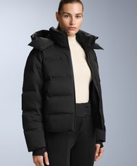 Crna puf jakna s krojenjem do struka, s patentnim zatvaračem, kopčanjem na dugmad i podesivom kapuljačom. Gladak, mat tekstil.