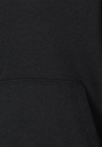 Schwarzer Hoodie aus einem weichen, strukturierten Stoff, mit einer mittigen Kängurutasche und dekorativen Nähten entlang der Nähte für zusätzliche Haltbarkeit.