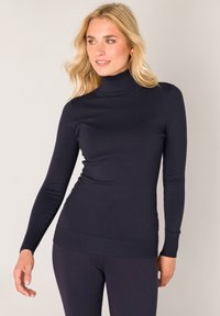 Marineblauwe coltrui van soepel breimateriaal, slim fit ontwerp, lange mouwen, geribbelde manchetten en zoom, gecombineerd met bijpassende legging.