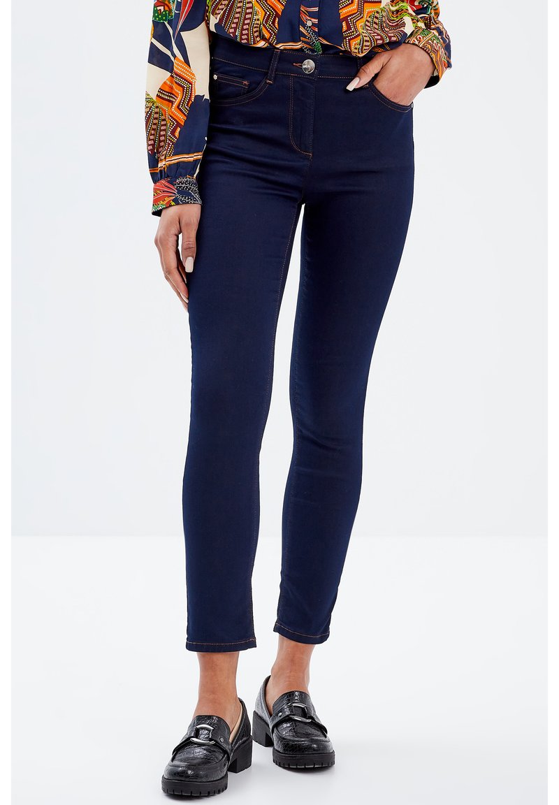 Jeans skinny blu scuro con vita alta, dotati di chiusura anteriore con bottone, due tasche posteriori e dettagli di cucitura discreti lungo le cuciture.