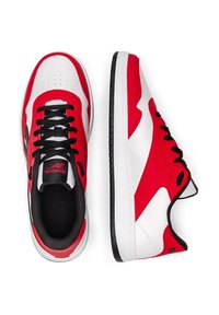 Piros, fehér és fekete alacsony szárú sportcipők fekete fűzőkkel, az egyik cipő felülről, a másik oldalról látható, fehér háttéren.