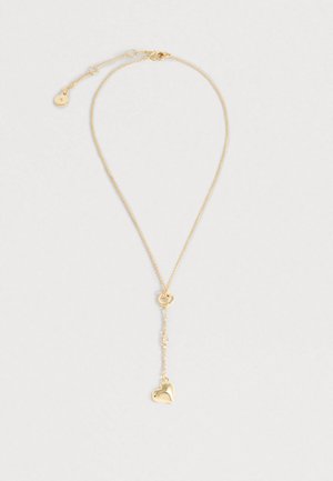 Zlatna ogrlica s nježnim lancem, ovalnim spojnikom i malim privjeskom u obliku srca sa sjajnom površinom, koja prikazuje jednostavan, ali elegantan dizajn.