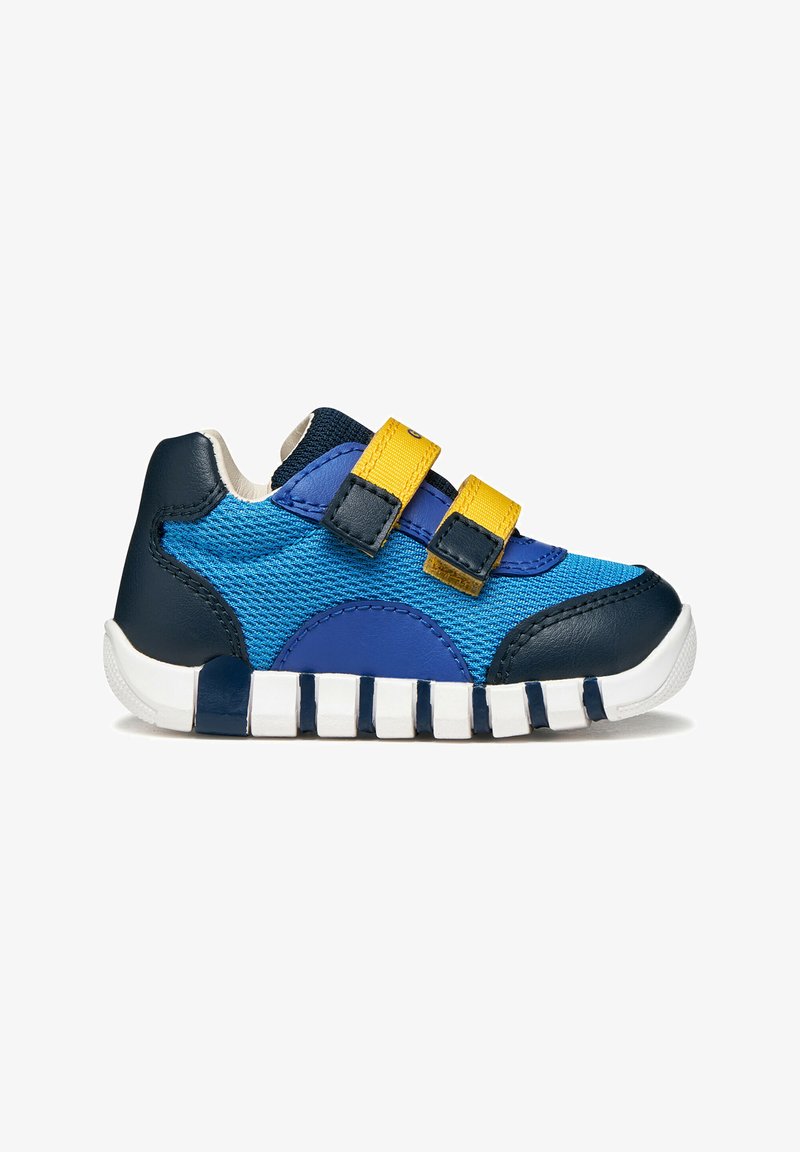 Chaussure de sport bleue avec panneaux en cuir et mesh, équipée de bandes auto-agrippantes jaunes, d'une semelle en caoutchouc blanche et d'un design texturé.