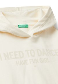 Felpa color crema con una texture morbida, dotata di cappuccio e stampa in marrone chiaro: "HO BISOGNO DI BALLARE, DIVERTIRMI RAGAZZA."