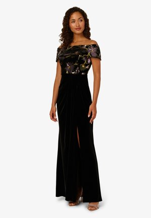 Schwarzes Samt-Über-die-Schultern-Kleid mit floraler Stickerei, langem fließenden Rock, seitlichem Schlitz und einem taillierten Oberteil. Texturiertes Material und elegantes Design.