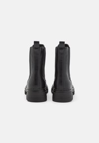 Black leather ankle boots with a smooth texture, elastic side panels, sturdy soles, and pull tabs at the back for easy wear.