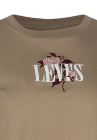 Camiseta de algodón beige con el logo blanco de "LEVI'S" bordado en rosa, escote redondo y mangas cortas.