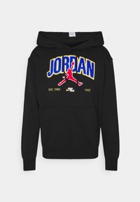 Svart hoodie av mjukt tyg med flerfärgad broderad text "JORDAN" och en röd Jumpman-logga på framsidan. Inkluderar en framficka.