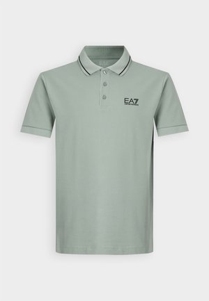 Polo shirt verde chiaro con colletto, patta con tre bottoni, rifiniture nere e logo EA7 sul lato sinistro del petto. Maniche corte, materiale in cotone.