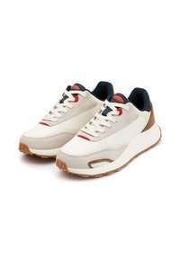 Smukłe sneakersy z kremową skórą i szarym zamszem na górze, czerwonymi akcentami, granatową podszewką i gumową podeszwą z teksturowanym wzorem bieżnika.