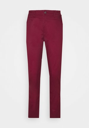 Bordowe spodnie o prostych nogawkach z zapięciem na guzik i zamek błyskawiczny, szlufkami na pasek i przednimi kieszeniami na jednolitym białym tle.