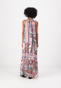 Abito lungo senza maniche caratterizzato da un mix di motivi paisley e geometrici in rosa, verde e rosso, con una silhouette fluida e colletto con lacci.