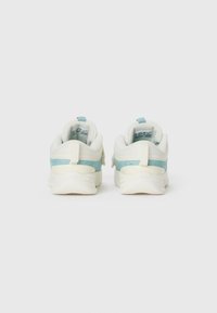 Une paire de baskets blanches et bleu clair vues de l'arrière sur un fond blanc uni.