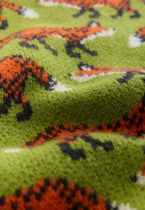 Grüner gestrickter Stoff mit einem orange-schwarzen Fuchs-Muster und weißen Akzenten. Die Textur wirkt weich und leicht flauschig.