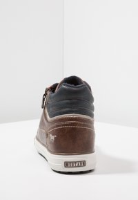 Brown leather sneaker featuring a navy back, white stitching, and a zip closure. Includes a light-colored sole and a small horse logo.