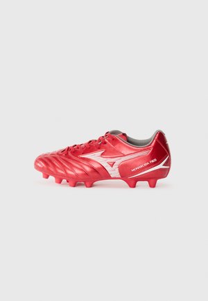Red soccer cleat with a textured, shiny upper, featuring white accents and a prominent logo. Designed for traction with multiple studs.