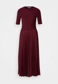 Burgunderfarget plissékjole med korte ermer, en tettsittende bodice og rund hals. Har strukturert stoff og diskret logodetaljering.