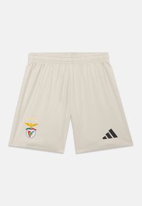 Shorts de sport beige clair avec une taille élastique. Présentent un emblème de Benfica et trois étoiles sur le côté gauche, ainsi qu'un logo Adidas noir sur la droite.