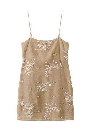Beiger ärmelloser Kleid mit dünnen Trägern, verziert mit weißen Blumenstickereien, die über den Stoff verteilt sind.