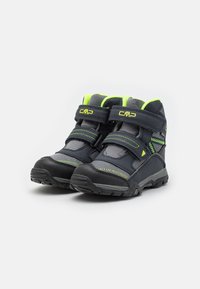 Zapatos de senderismo negros y grises con acentos en verde brillante. Cuentan con correas de Velcro, material texturizado, suela de goma y cuello acolchado.