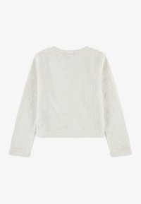 Minkštas baltas ilgomis rankovėmis marškinėliai, laisvo kirpimo ir apvaliu iškirpimu, su tekstūruotu audiniu ir trumpu ilgiu. Jokie užtrauktukai nėra matomi.