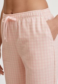 Roze geruite pyjamabroek van zachte stof met een elastische tailleband en trekkoord, voorzien van zijzakken en een comfortabele pasvorm.