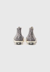 High-top sneakers in gray snake print, featuring a textured surface, white rubber sole, and black branding on the heel.