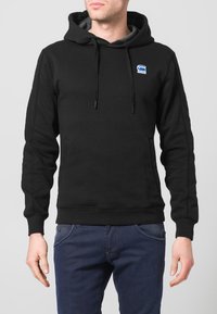 Felpa nera con cappuccio, tasca frontale e coulisse. Presenta un logo blu sul petto. Realizzata in materiale soffice e testurizzato.