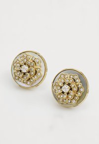 Boucles d'oreilles en or avec un design floral, agrémentées de strass transparents sur une base circulaire, accentuées d'un revêtement semblable à une perle.