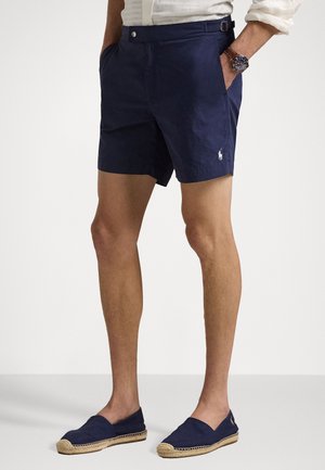 Marineblauwe shorts met een minimalistisch ontwerp, voorzien van zijzakken, een detail in de tailleband en een klein logo op het linkerkoot. Smalle stofstructuur.
